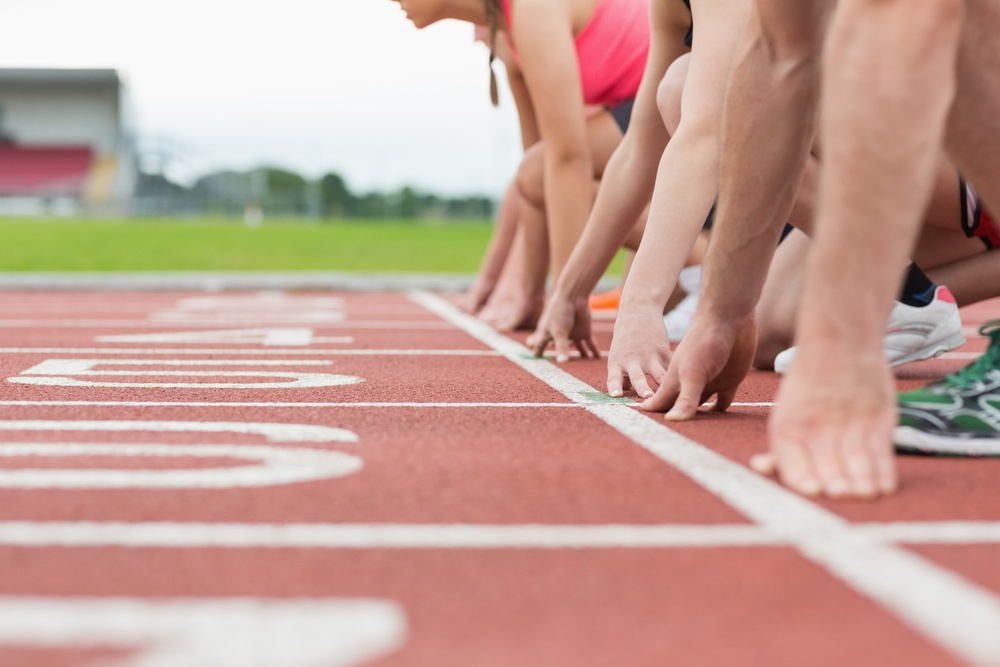 Close-up side view of cropped people ready to race on track field.jpeg