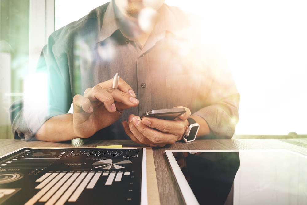 businessman working with digital tablet computer and smart phone with digital business strategy layer effect on wooden desk as concept.jpeg